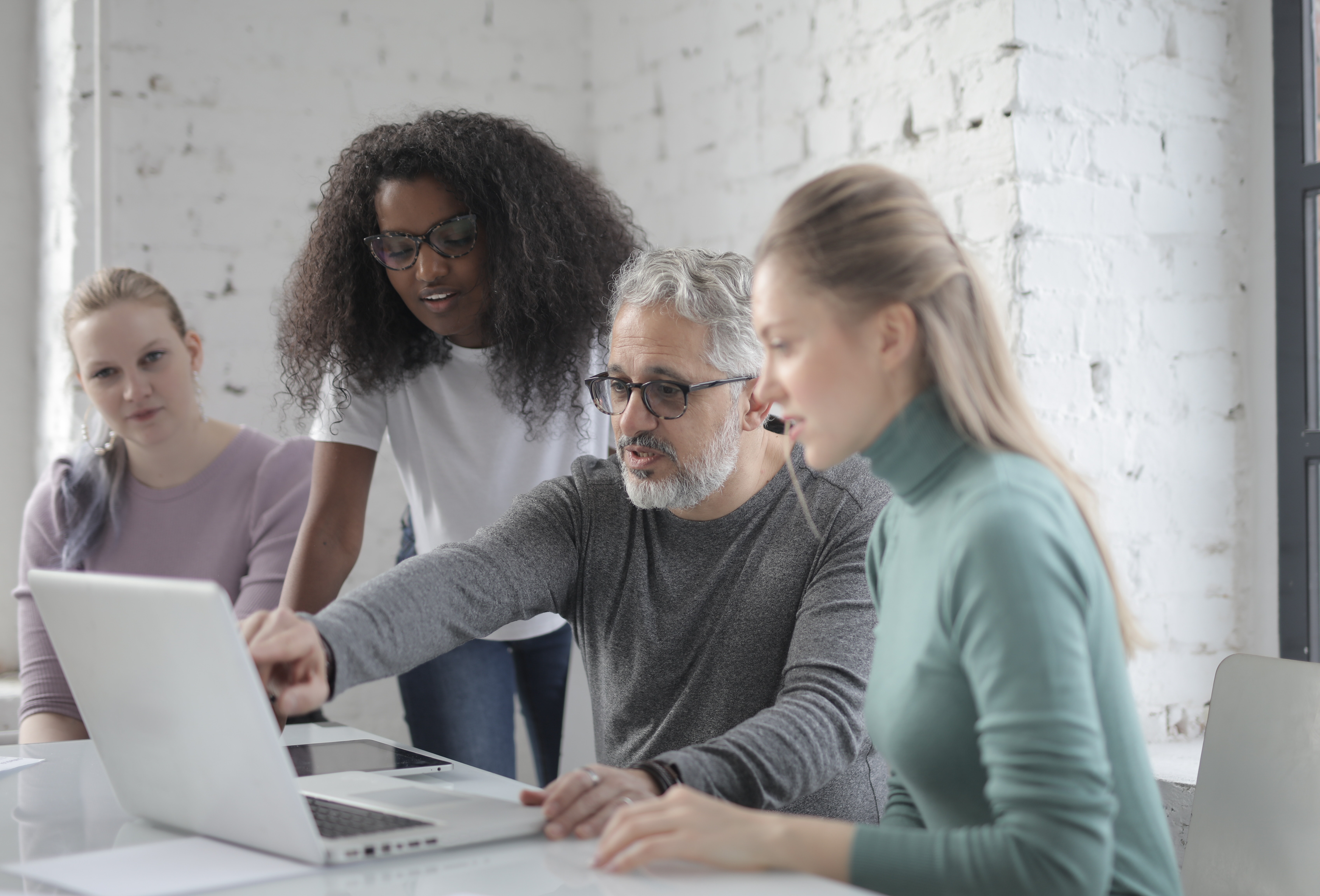 A man showing his screen to other employees